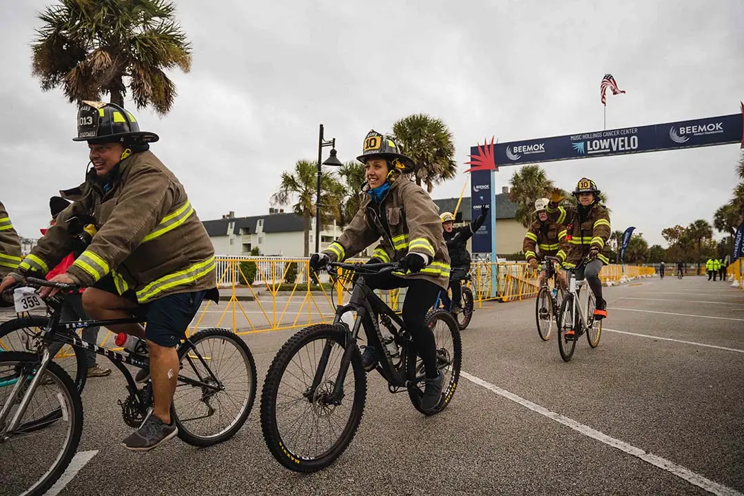 firefighters cross the finish line wearing their fire equipment