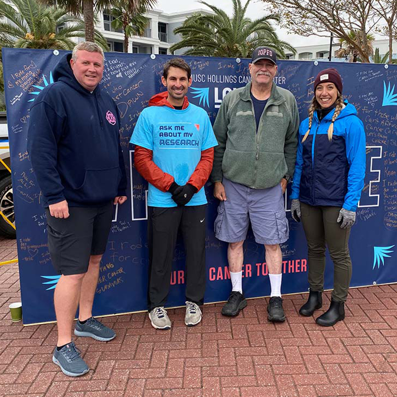 group stands in front of why I ride wall