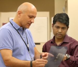 two hollings researchers discuss findings in the lab