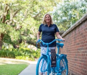 kathy cole stands with a bike painted blue for lowvelo