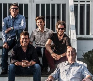 blue dogs band members sit on steps outside