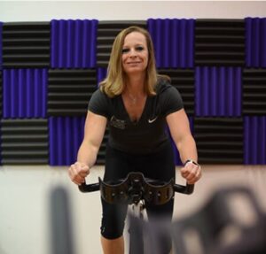 nicki carter riding exercise bike in a gym