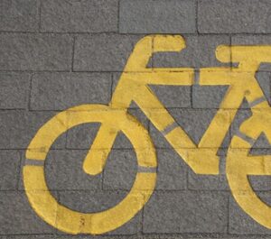 yellow bike icon painted onto a sidewalk