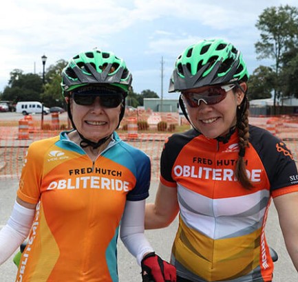 nancy and heather evans stand together with cycling gear on