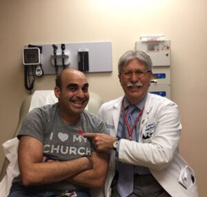 nick charalambous and dr robert stuart sit together in a medical exam room
