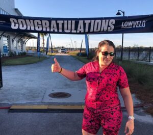 rita barbagallo gives a thumbs up standing at the lowvelo 19 finish line