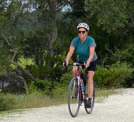 kathy edwards rides her bike on a nature trail