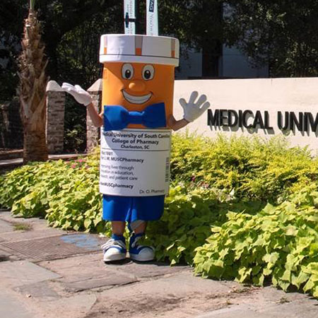 Phil the Pill mascot stands next to MUSC sign