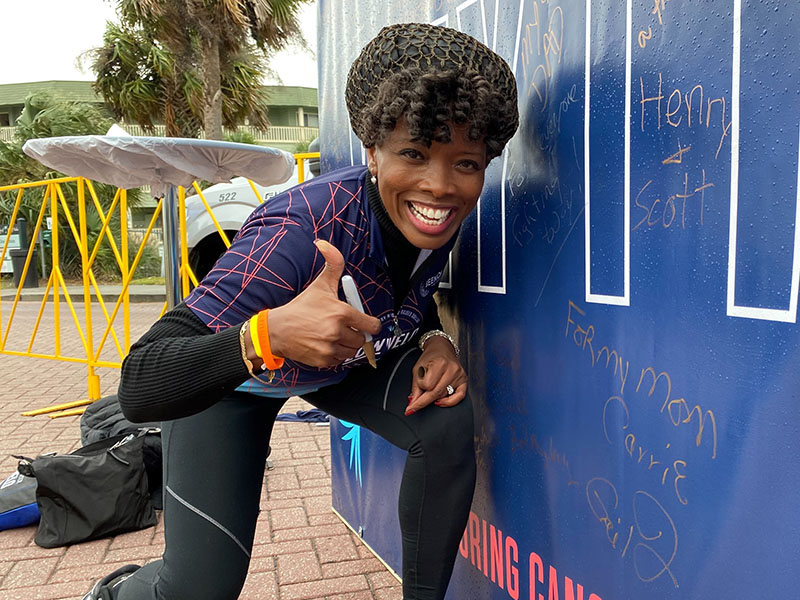 Ja'Net Bishop gives a thumbs up after writing a message on the Why I Ride wall