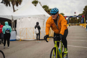 rider pedals past tents
