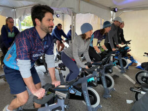 group of people riding stationary bikes in tent at Lowvelo21