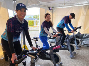 three riders in stationary cycle tent