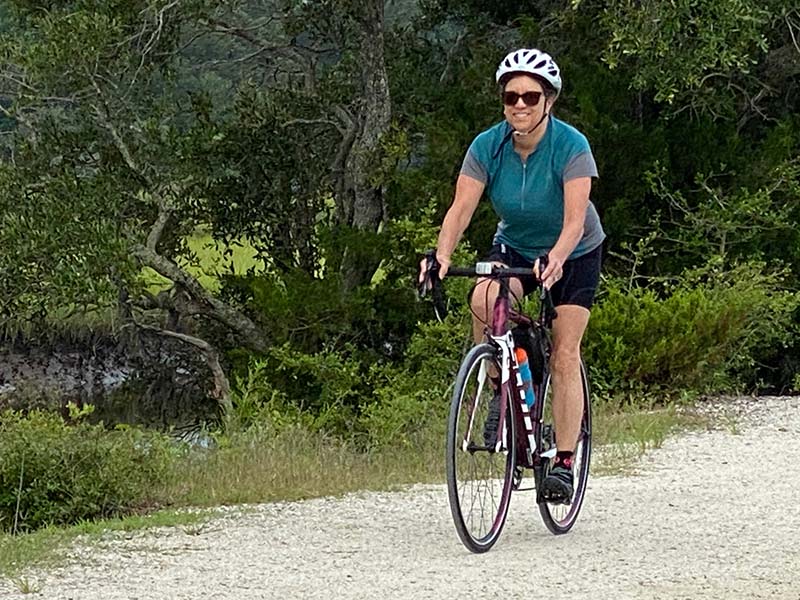 woman rides her bike on a nature trail