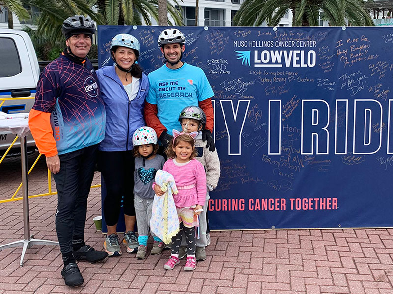 Scott Wentzky, Dr. Evan Graboyes and his family at the Why I Ride wall at LOWVELO21