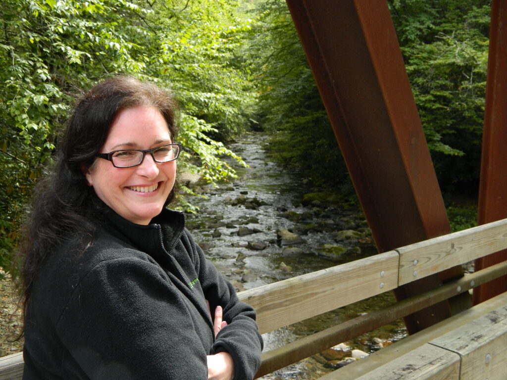 woman standing on a footbridge smiling