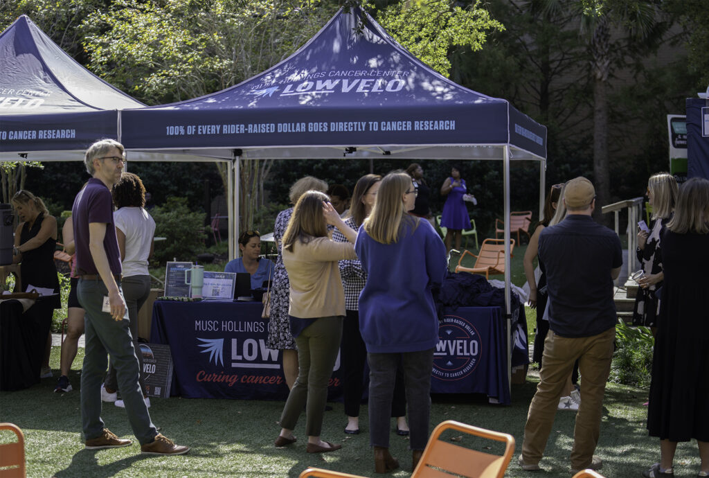 People mingling around the Lowvelo table on the MUSC Greenway