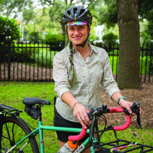 woman wearing helmet standing with bicycle