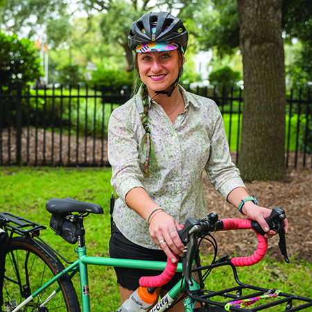 woman wearing helmet standing with bicycle
