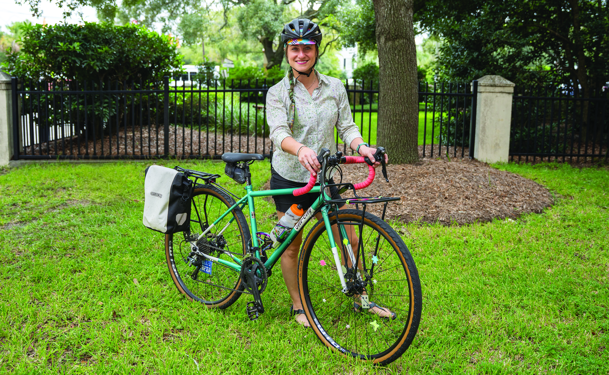 Sylvie Baele standing in a grassy area with a bike