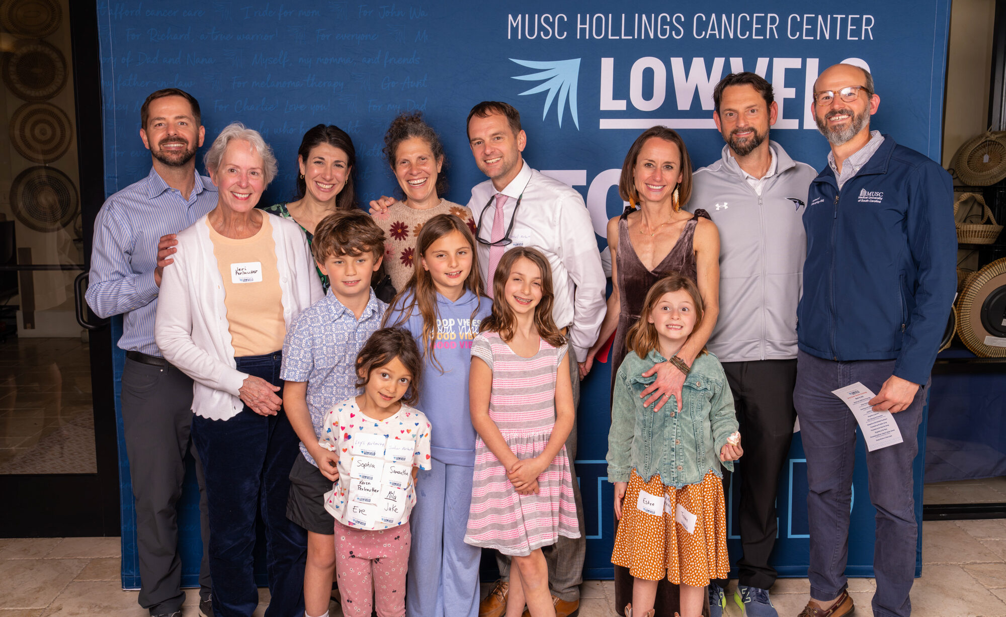 Attendees of the Lowvelo 25 awards ceremony pose in front of a backdrop that says too inspired to be tired