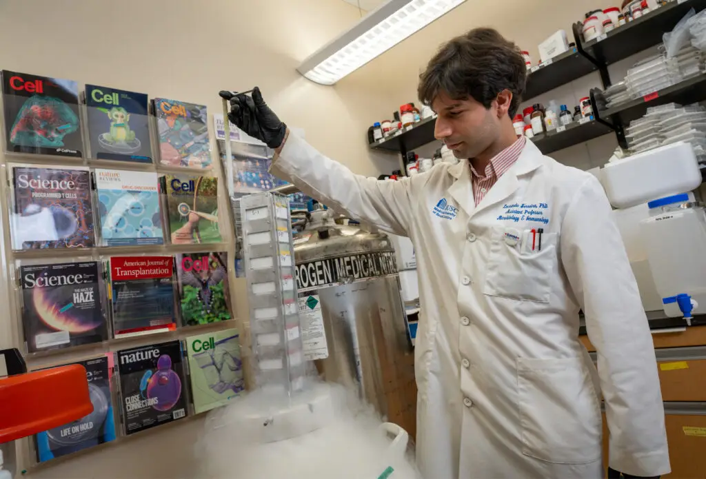 man pulls lab equipment out of container of dry ice
