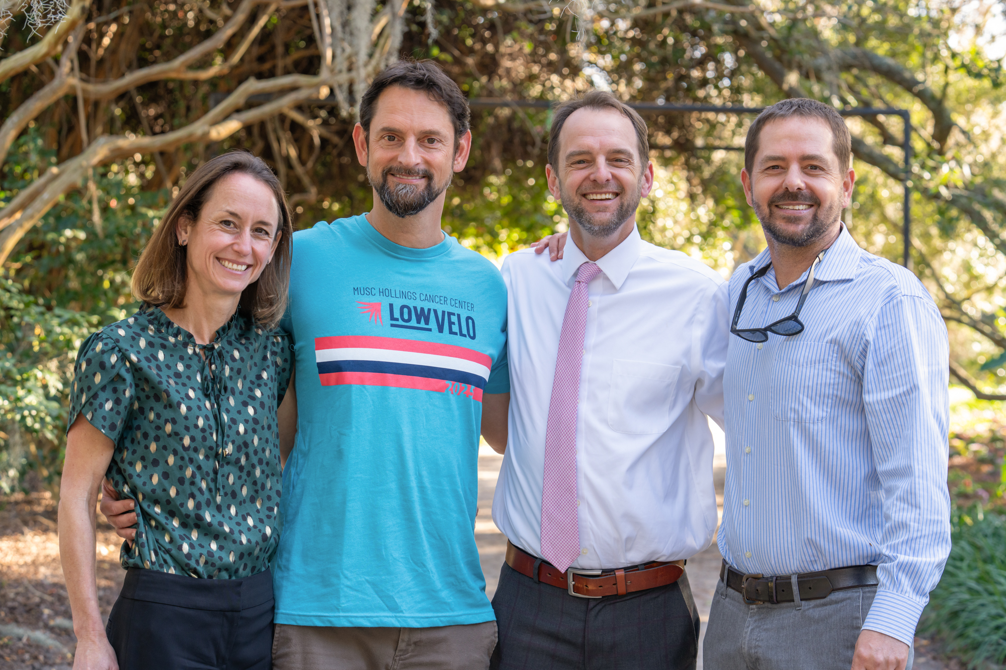 Four people stand in a park together. One wears a Lowvelo t shirt.