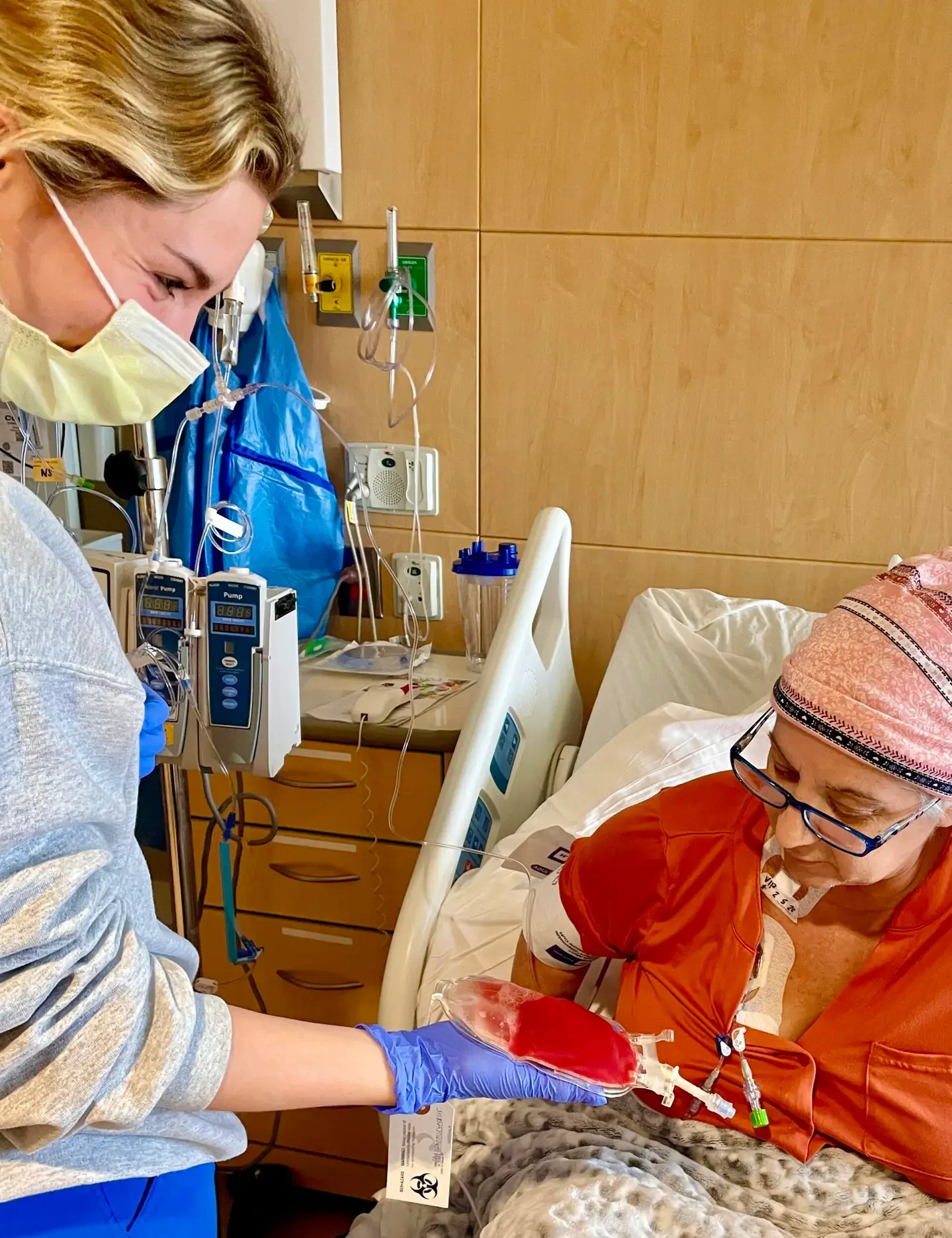 a hospital worker shows a patient a bag of fluid