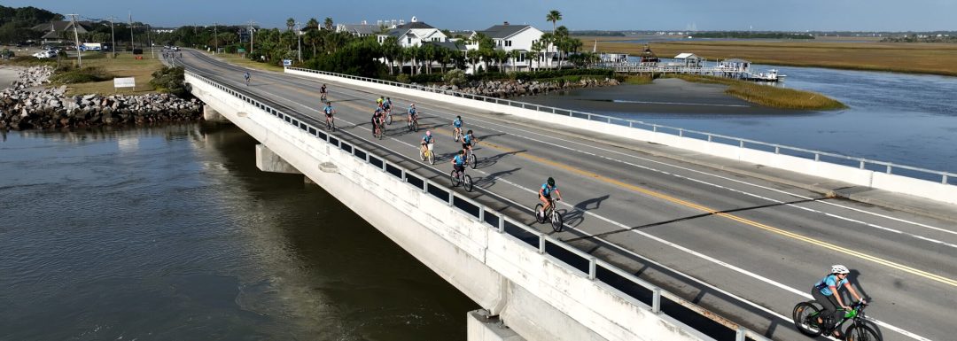 cyclists ride over Breach Inlet