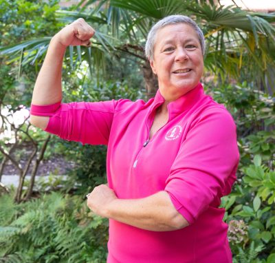 woman in pink shirt flexing for camera