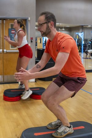 man and woman working out in a gym during a HIIT class