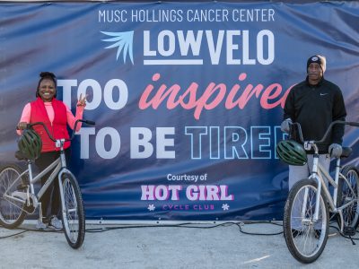 man and woman with bikes in front a sign that says too inspired to be tired