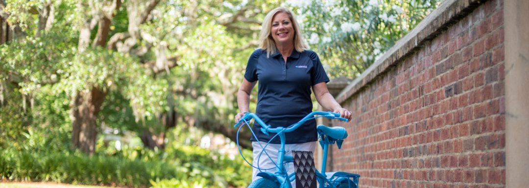 kathy cole stands with a bike painted blue for lowvelo