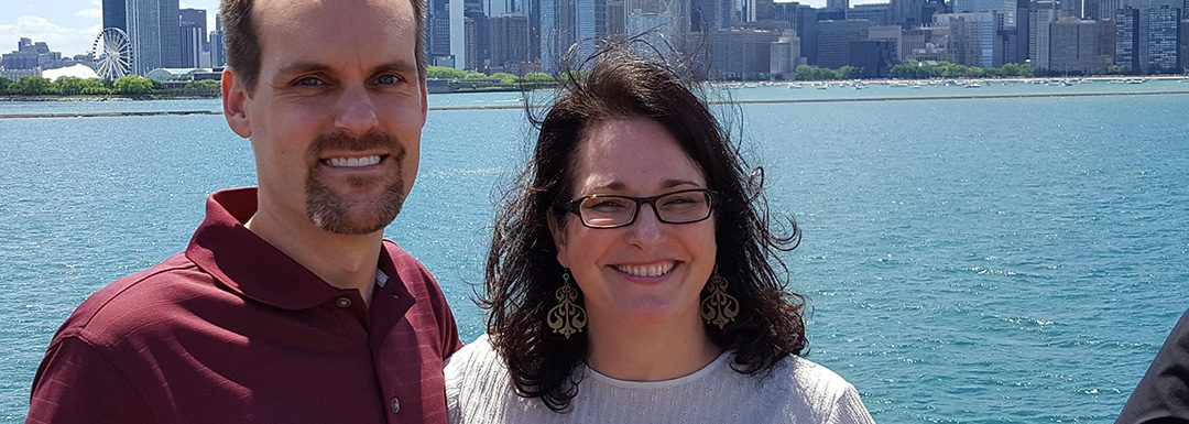Aron and Heather Kuch stand in front of the Chicago skyline
