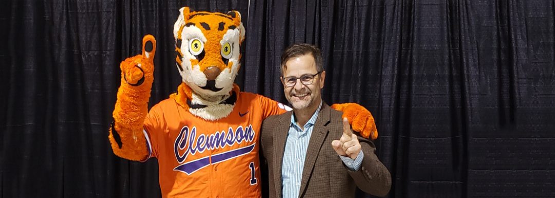 clemson university mascot and gustavo leone hold up their index fingers in number 1 gesture